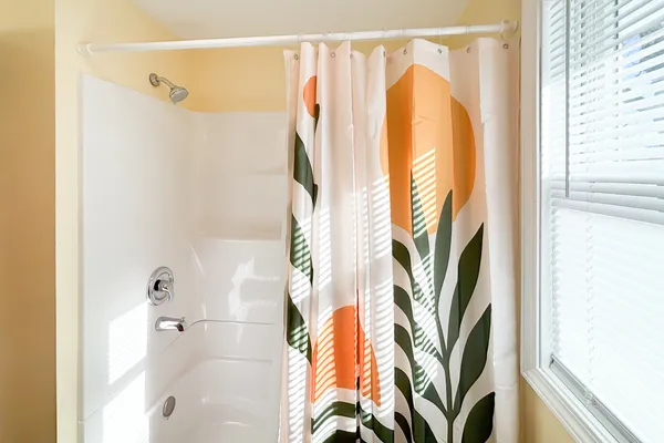a bathroom with a shower curtain and a window