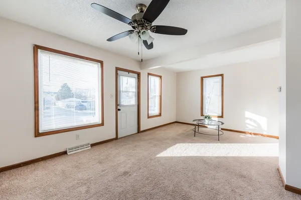 an empty room with windows and ceiling fan view
