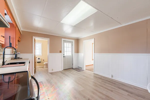 a view of a kitchen with furniture and wooden floor