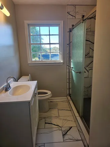 a bathroom with a sink toilet and shower