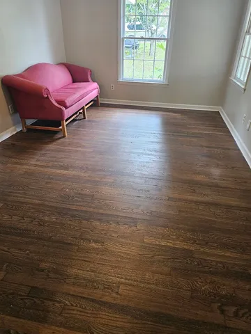 a view of a room with wooden floor and a window
