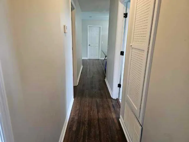a view of a hallway with wooden floor and stairs