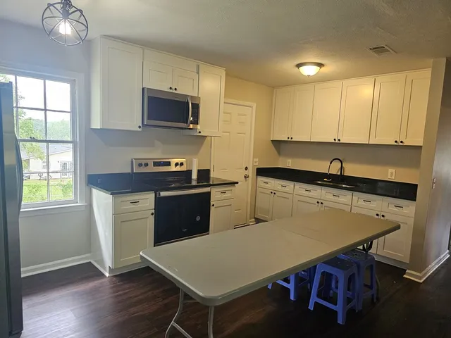 a kitchen with a stove a sink and a microwave