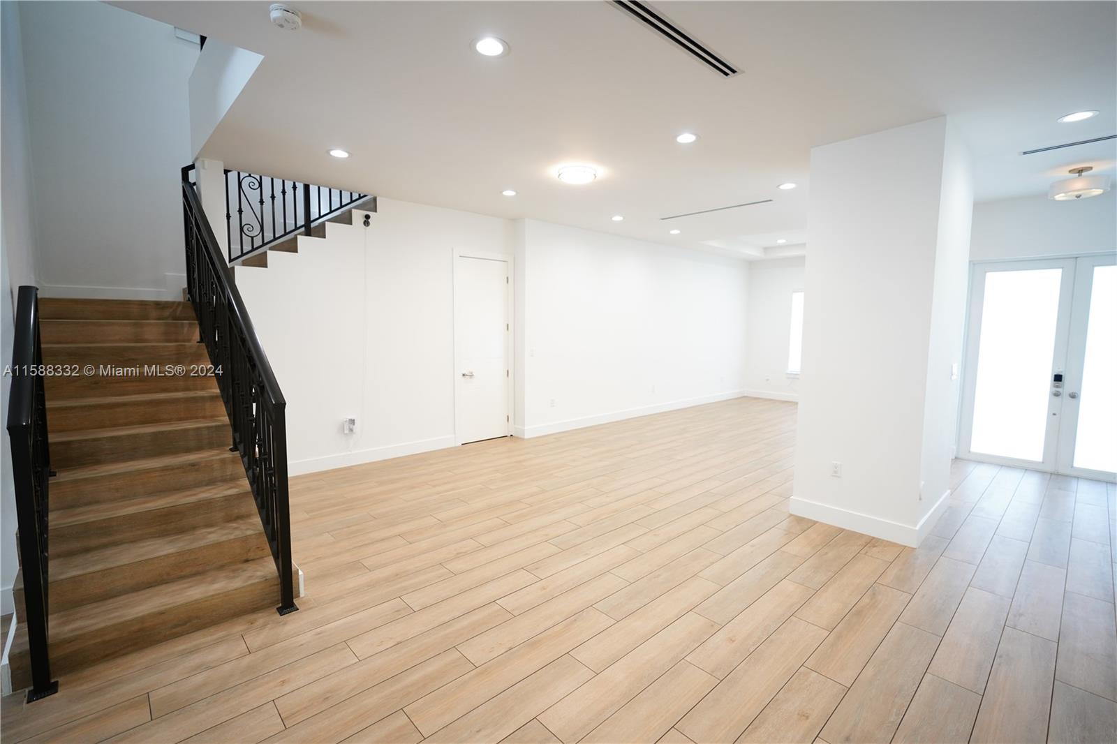 429 Southwest 23rd Road Miami, FL 33129 - Photo 13 of 46 a view of an empty room with wooden floor and stairs