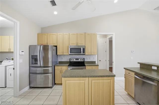 a kitchen with stainless steel appliances granite countertop a refrigerator stove and microwave