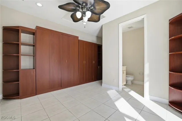 a view of an empty room and a bathroom with a shower