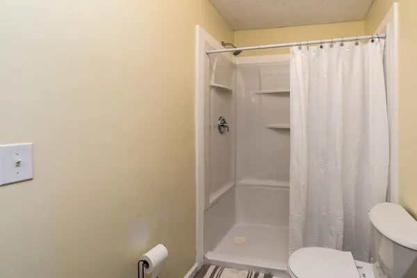 a bathroom with a shower curtain and a toilet