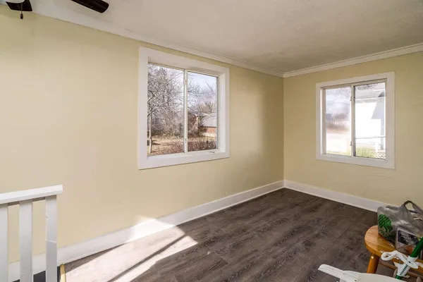 a view of a room with wooden floor and windows