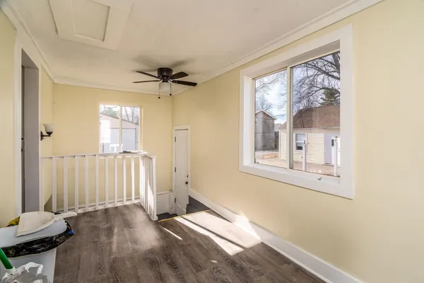 a view of a livingroom with wooden floor and a ceiling fan