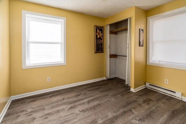 an empty room with wooden floor and a window