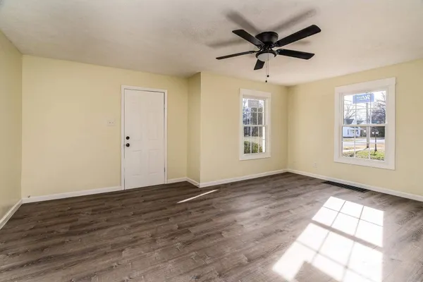 a view of empty room with wooden floor and ceiling fan