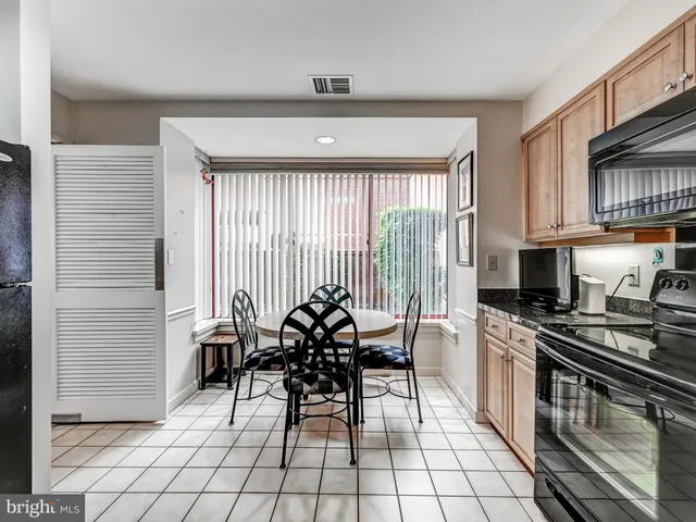 a kitchen with granite countertop a stove a sink and a refrigerator