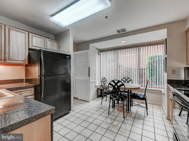 a kitchen with stainless steel appliances a table and chairs