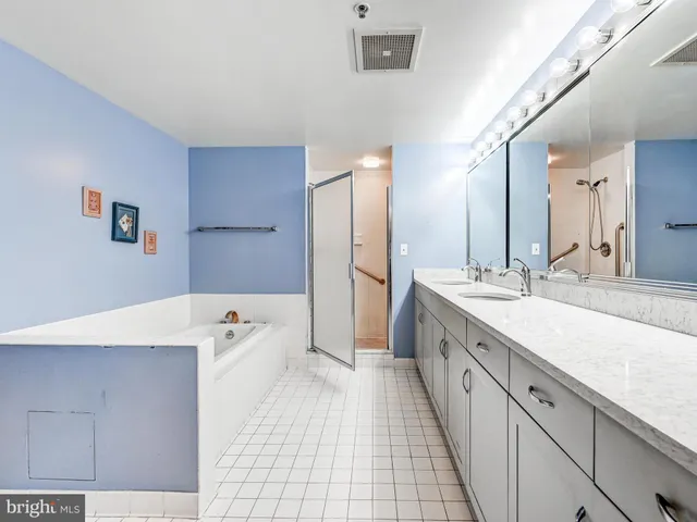 a large bathroom with a large mirror vanity and shower