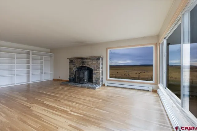 a view of an empty room with a fireplace and a window