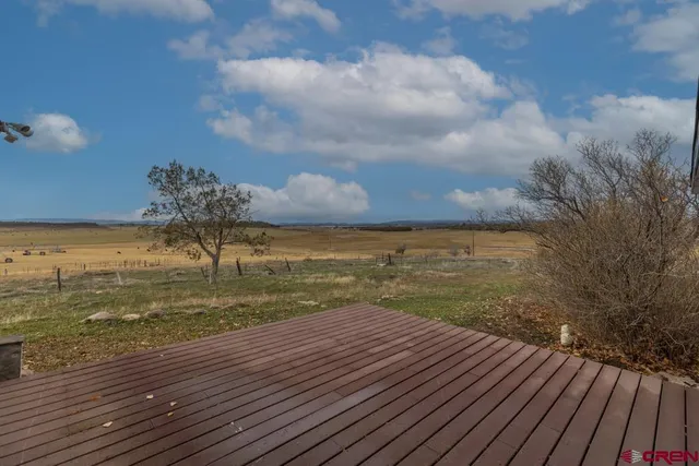 a view of a hallway with wooden floor and a bathroom