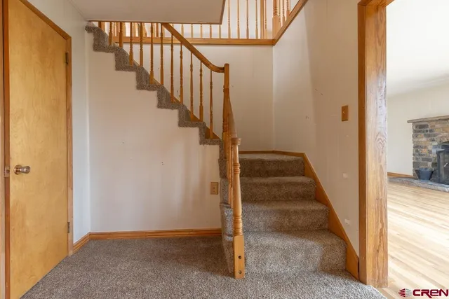 a view of a hallway with wooden floor and stairs