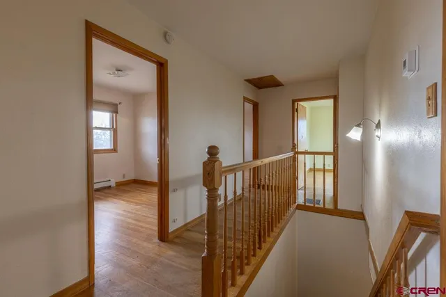 a view of a hallway with wooden floor and windows