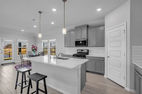 a kitchen with kitchen island granite countertop stainless steel appliances cabinets a sink and a stove