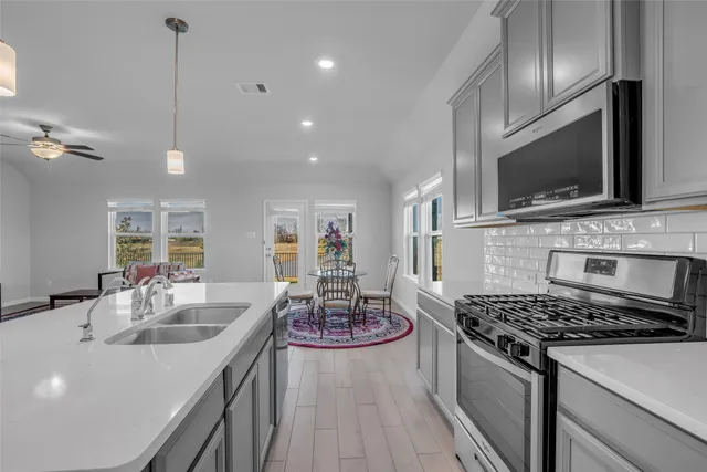 a kitchen with a stove a sink and a microwave