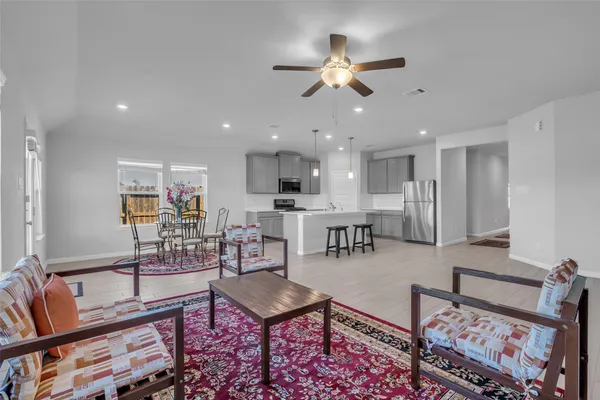 a living room with lots of furniture and view of kitchen