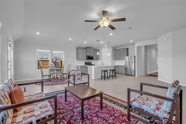 a living room with lots of furniture and view of kitchen