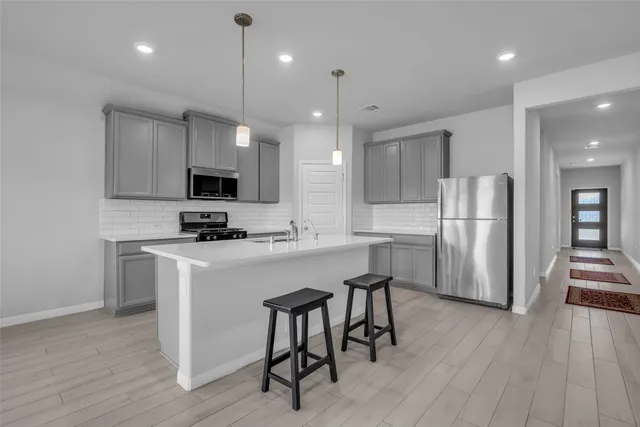 a kitchen with kitchen island white cabinets and stainless steel appliances