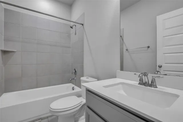 a bathroom with a bathtub shower sink vanity mirror and toilet