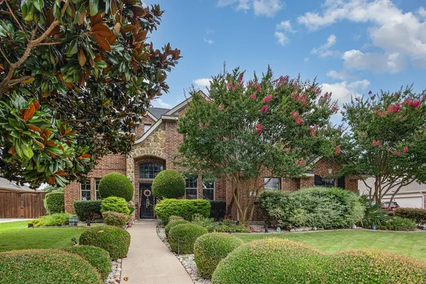 a front view of a house with a yard and potted plants