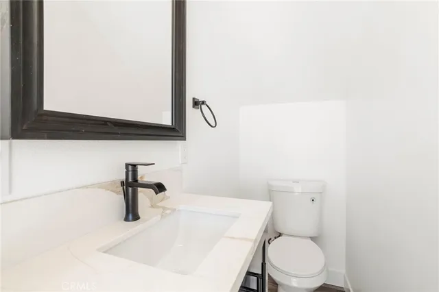 a bathroom with a toilet a sink and mirror