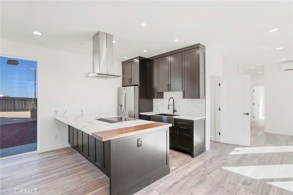 3460 Stonehill Avenue Joshua Tree, CA 92252 - Photo 6 of 27 a kitchen with stainless steel appliances kitchen island a sink stove and refrigerator