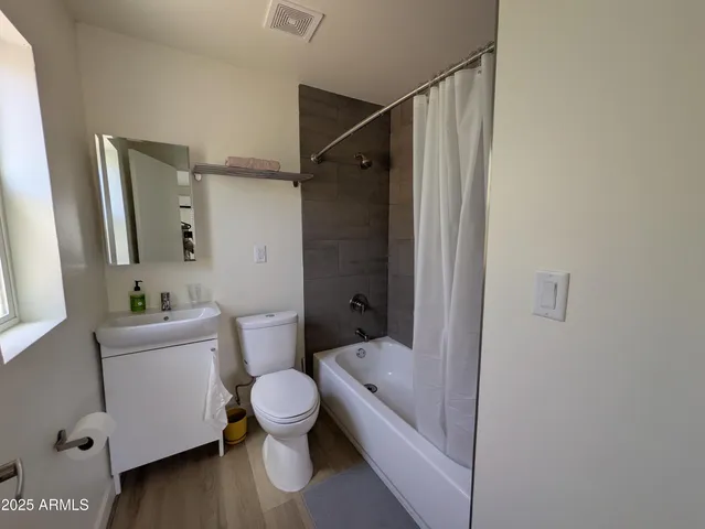 a bathroom with a granite countertop sink mirror vanity and toilet