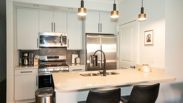 a kitchen with kitchen island a sink stove and white cabinets