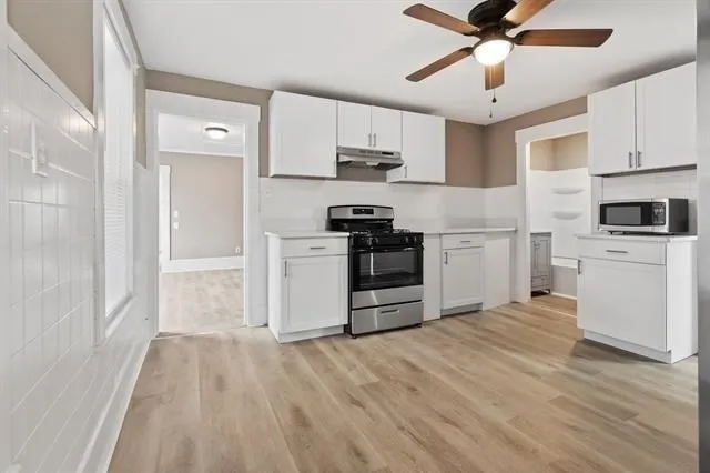 a kitchen with stainless steel appliances a white cabinets and sink
