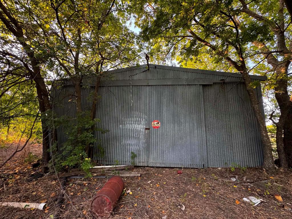 4270 Belz Road Sanger, TX 76266 - Photo 24 of 40 Corrugated metal building with a gabled roof surrounded by mature trees