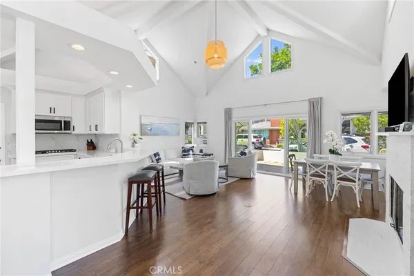 a kitchen with stainless steel appliances granite countertop a stove top oven a dining table and chairs with wooden floor