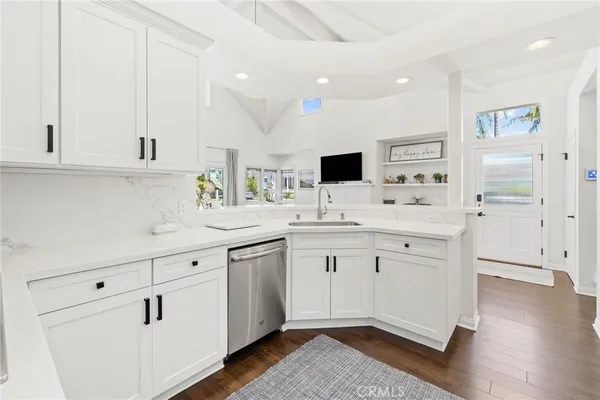 a kitchen with granite countertop a sink and white cabinets