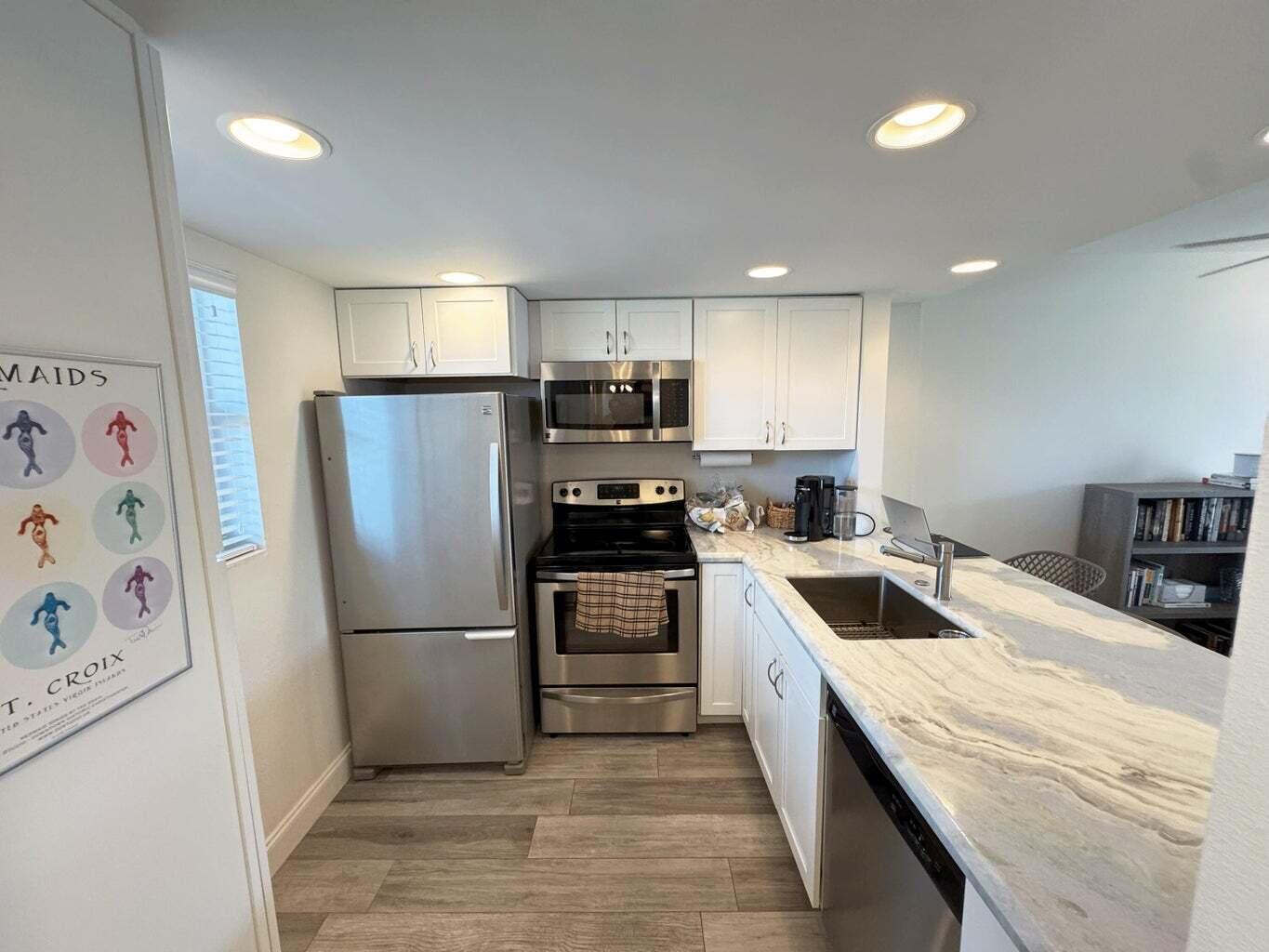 2929 South Ocean Boulevard, Unit 4130 Boca Raton, FL 33432 - Photo 2 of 17 a kitchen with a refrigerator sink and wooden cabinets