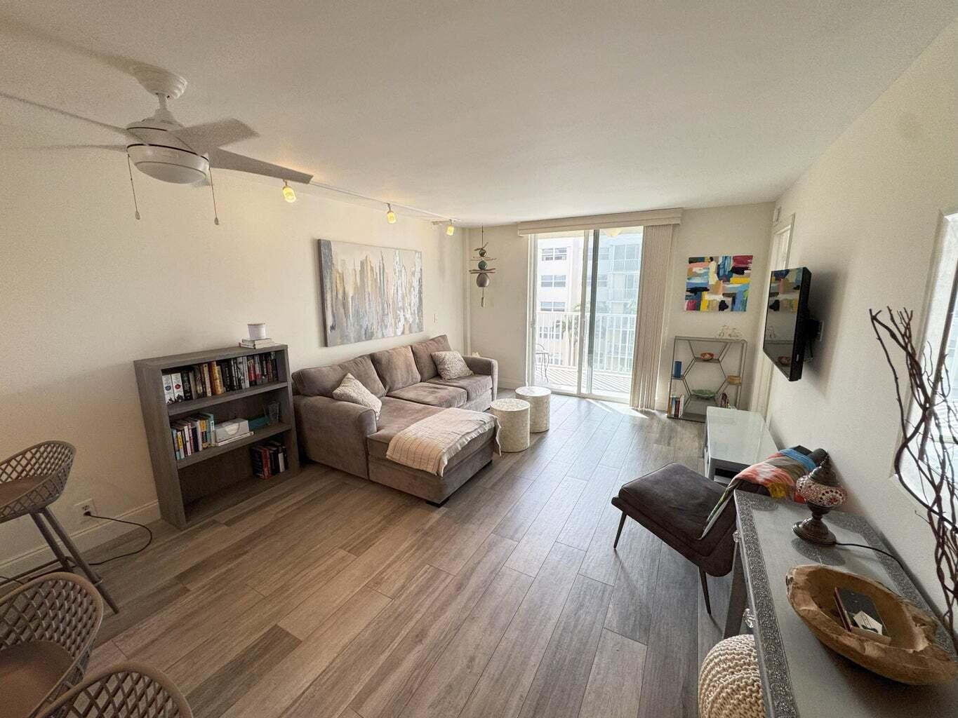 2929 South Ocean Boulevard, Unit 4130 Boca Raton, FL 33432 - Photo 3 of 17 a living room with furniture a flat screen tv and a large window