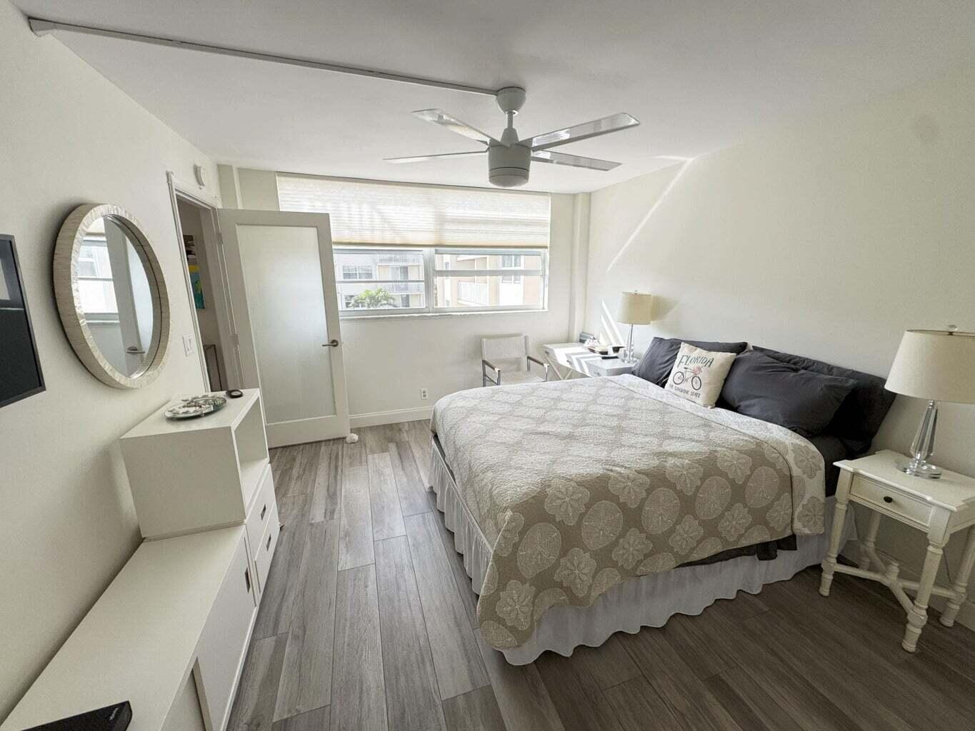 2929 South Ocean Boulevard, Unit 4130 Boca Raton, FL 33432 - Photo 5 of 17 a spacious bedroom with a bed a mirror on the dresser and a large window