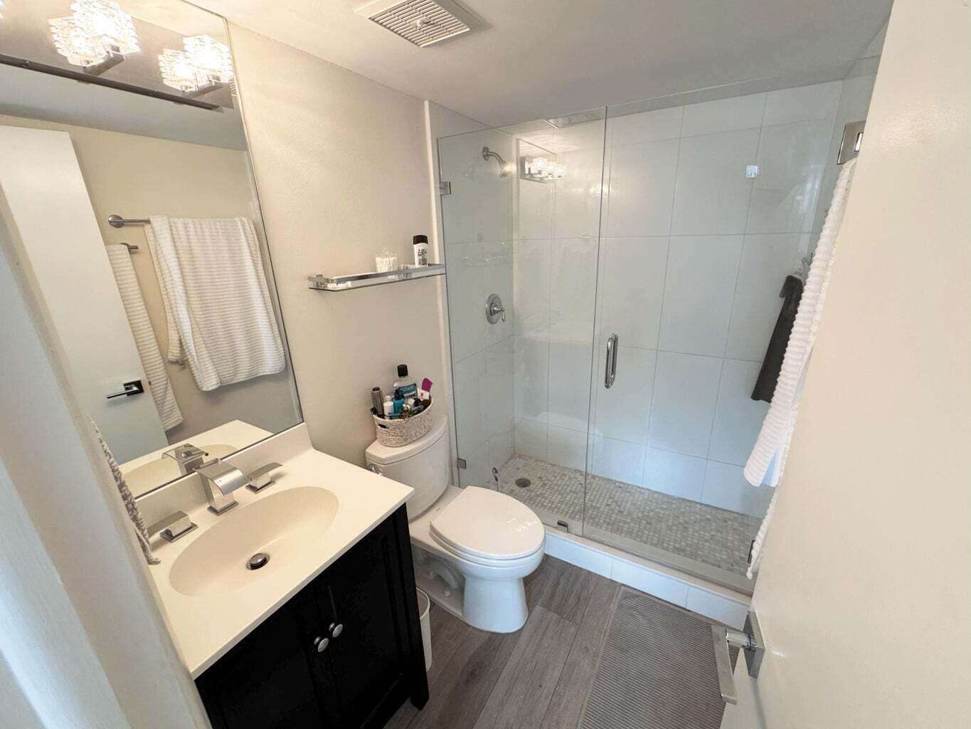 2929 South Ocean Boulevard, Unit 4130 Boca Raton, FL 33432 - Photo 6 of 17 a bathroom with a sink a toilet a mirror and shower