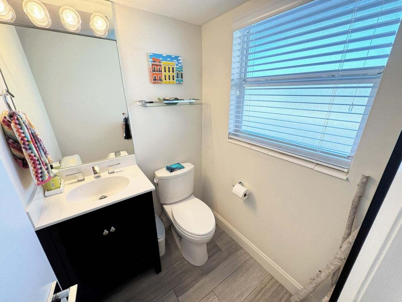 2929 South Ocean Boulevard, Unit 4130 Boca Raton, FL 33432 - Photo 8 of 17 a bathroom with a toilet sink and mirror