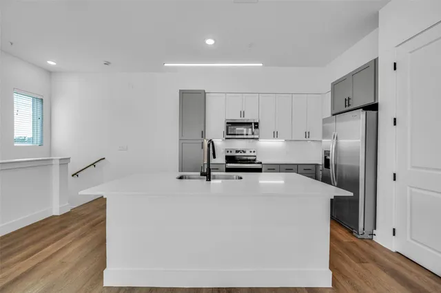 a kitchen with stainless steel appliances a refrigerator sink stove microwave and cabinets