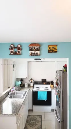 a kitchen with stainless steel appliances granite countertop a sink a stove and a refrigerator