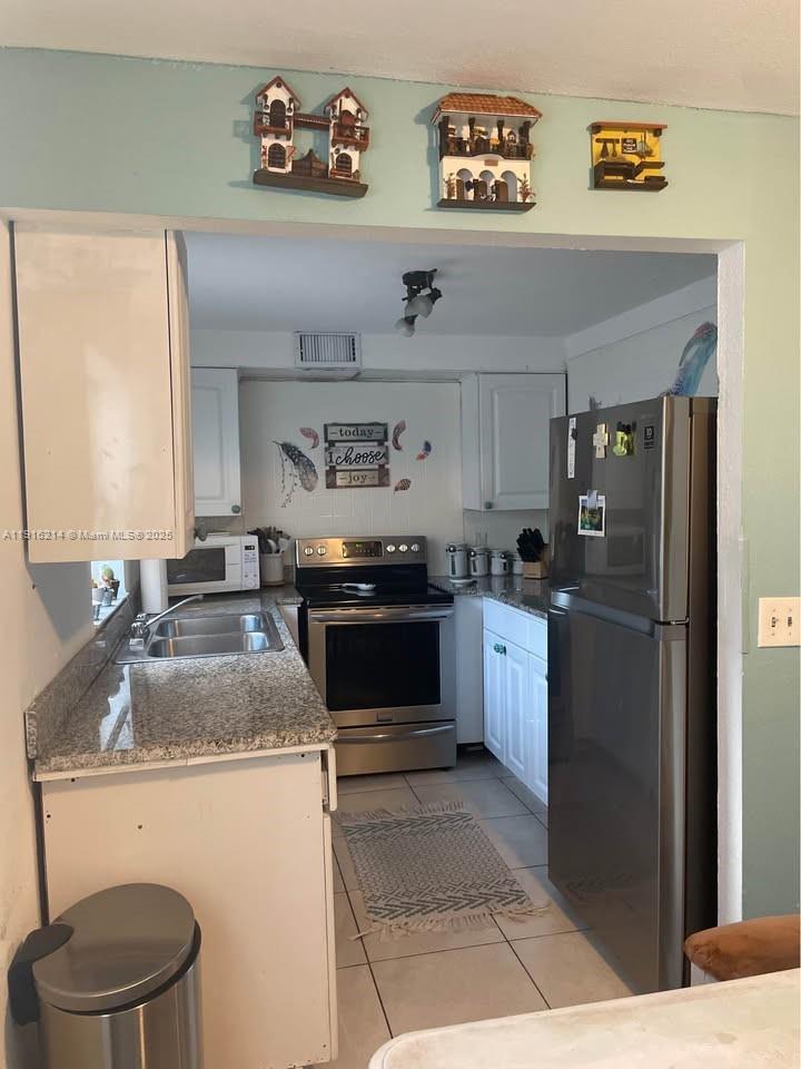 116 Tuscany Lane, Unit 116 Delray Beach, FL 33446 - Photo 9 of 12 a kitchen with a sink a stove and refrigerator