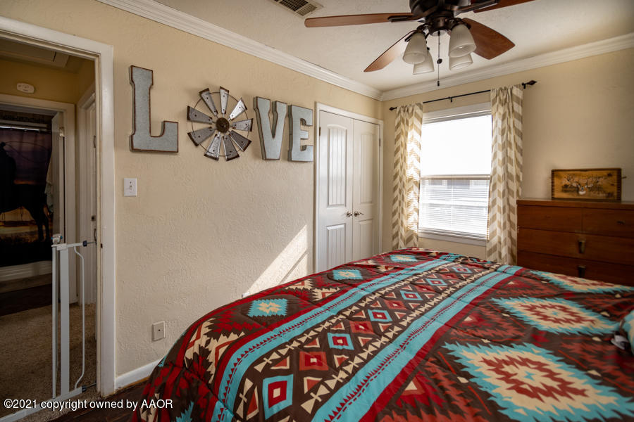 4207 South Lipscomb Street Amarillo, TX 79110 - Photo 13 of 23 a bedroom with a bed and a chandelier
