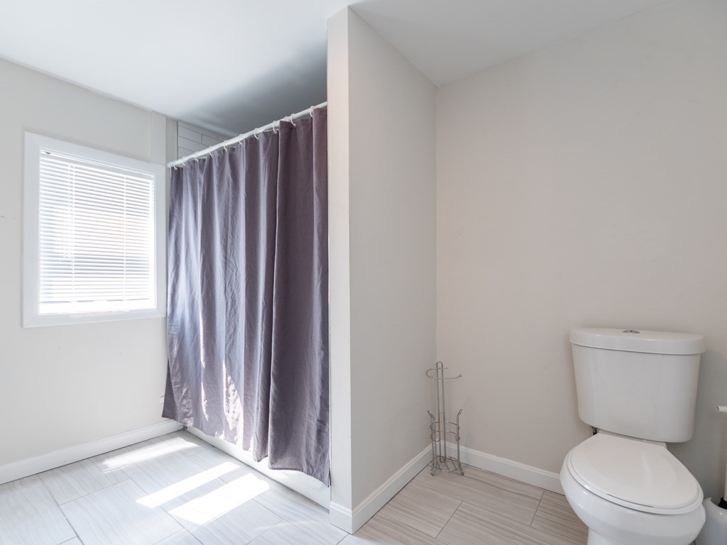 241-243 E Street Boston, MA 02127 - Photo 16 of 16 a bathroom with a toilet a window and shower