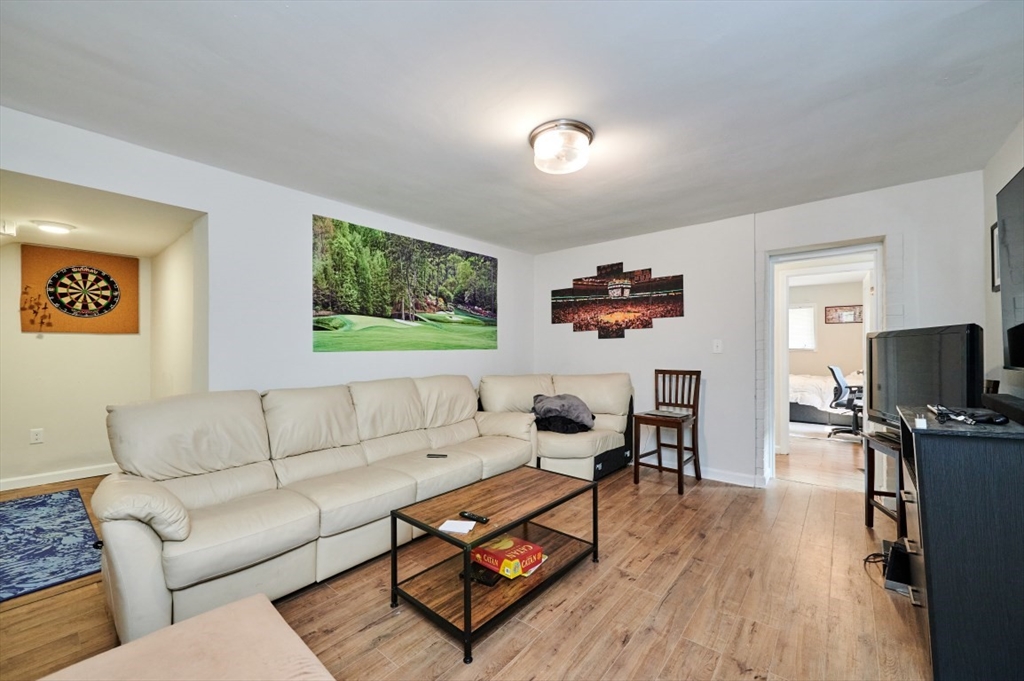 241-243 E Street Boston, MA 02127 - Photo 2 of 16 a living room with furniture a wooden floor and a flat screen tv