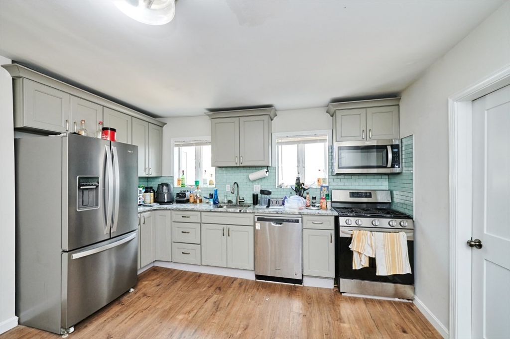 241-243 E Street Boston, MA 02127 - Photo 3 of 16 a kitchen with stainless steel appliances a refrigerator stove microwave and sink