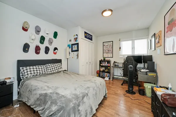 a bedroom with a bed and wooden floor